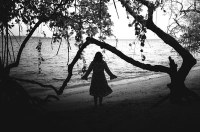 Rear view of silhouette woman standing on beach