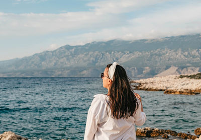 Woman looking at sea against mountain