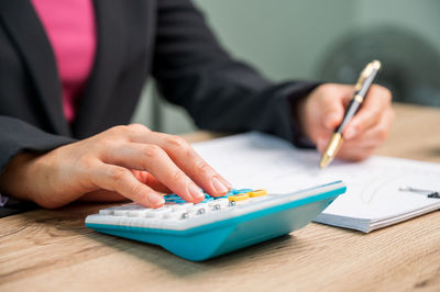 Midsection of man holding paper on table