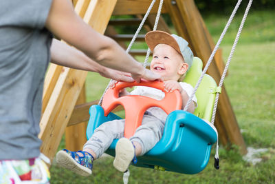 Portrait of boy swinging at playground