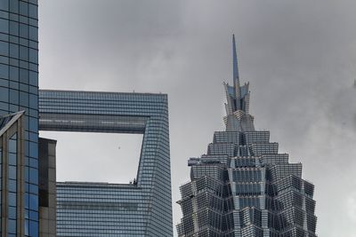 Low angle view of buildings against cloudy sky