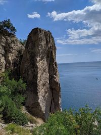 Rock formation in sea against sky