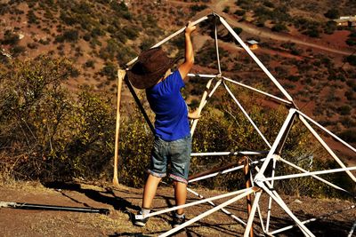 Boy making jungle gym on land