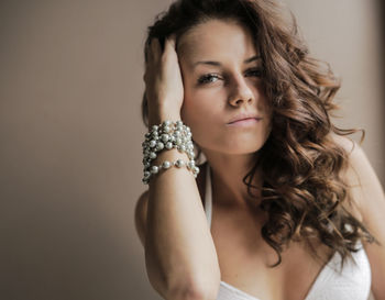 Portrait of beautiful young woman wearing bracelet over colored background