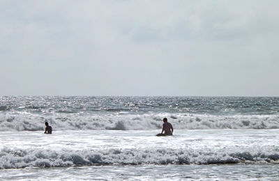 Men on beach against sky