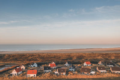 High angle view of townscape by sea against sky