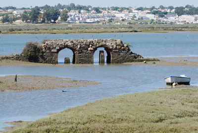 Built structure by sea against sky