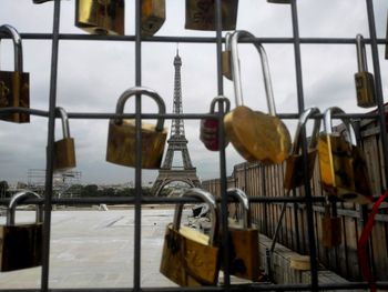 Close-up of padlocks hanging on metal by sea