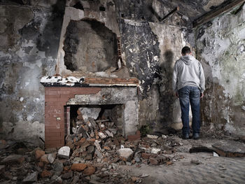 Rear view of man standing against wall