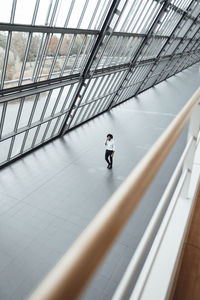 Young male professional walking by roof in office corridor