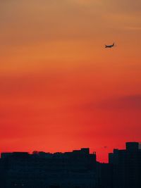 Airplane flying in sky at sunset