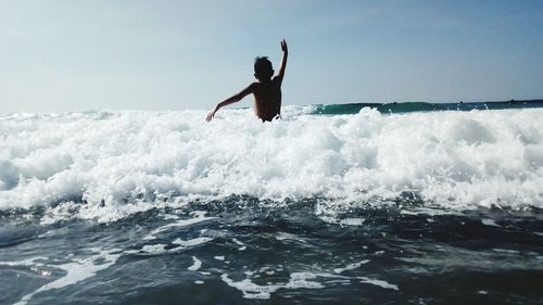 Man surfing on sea against sky