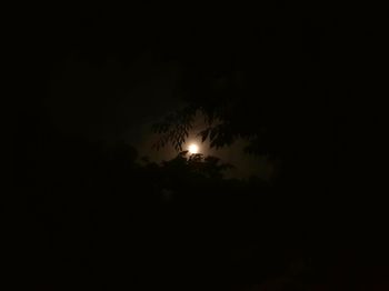 Low angle view of illuminated moon against sky at night