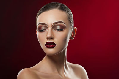 Close-up portrait of a woman against red background