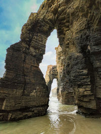 Rock formation in sea against sky