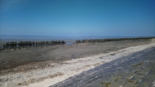 Scenic view of beach against clear blue sky