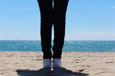 Low section of man standing on beach