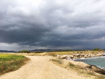 Scenic view of road by land against sky