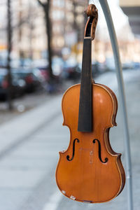 Close-up of violin hanging against street