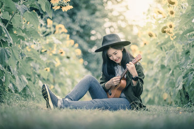 Woman playing guitar on field