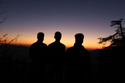 Silhouette people standing against sky during sunset