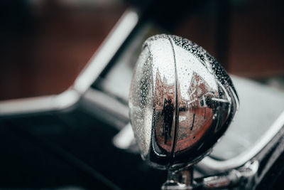 Close-up of wet side-view mirror