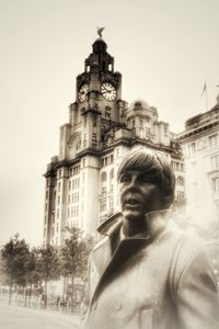 Portrait of man standing against building in city