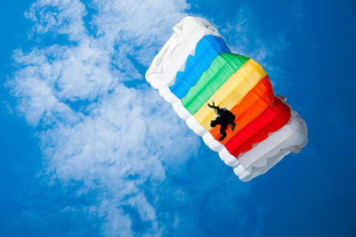 Low angle view of person parachuting against sky