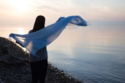 Woman looking at sea against sky