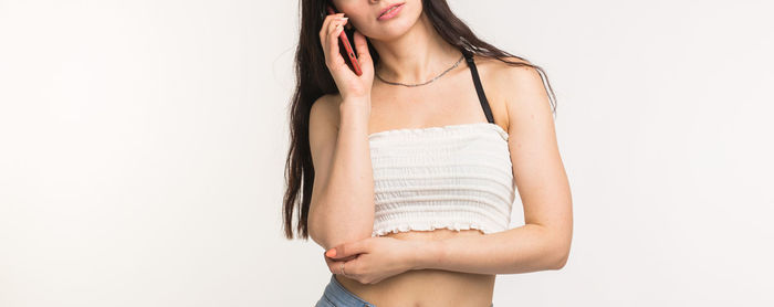 Midsection of woman standing against white background