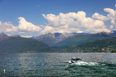 Boat on sea against mountains