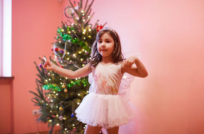 Girl standing with christmas tree