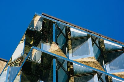 Low angle view of abandoned building against clear blue sky