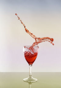 Close-up of red wine in glass against white background