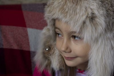 Close-up of girl wearing fur coat looking away