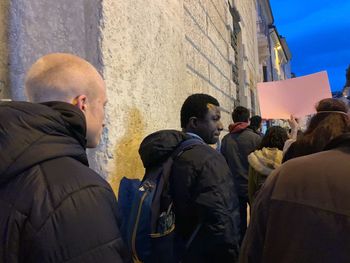 Rear view of people standing against buildings