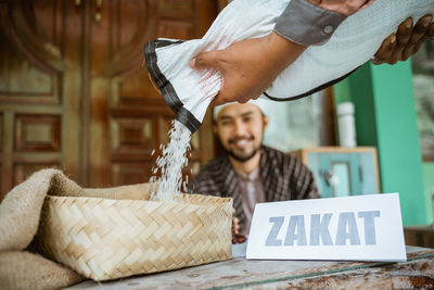 Man pouring rice in basket at mosque