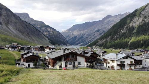 Houses on field by mountains against sky