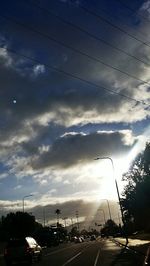 Traffic on road against cloudy sky