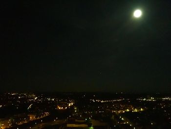 Illuminated cityscape against sky at night