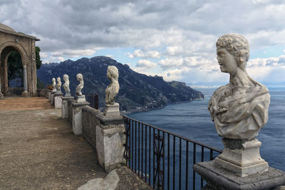 Statue by sea against sky