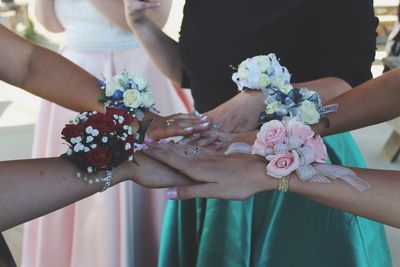 Midsection of bridesmaids stacking hands during wedding