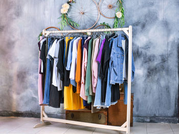 Multi colored clothes hanging on rack at home