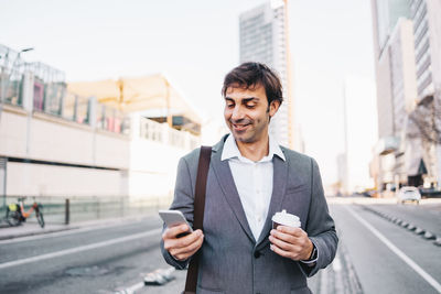 Young man using mobile phone in city