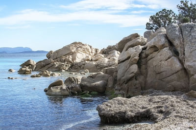 Rock formations on sea shore against sky