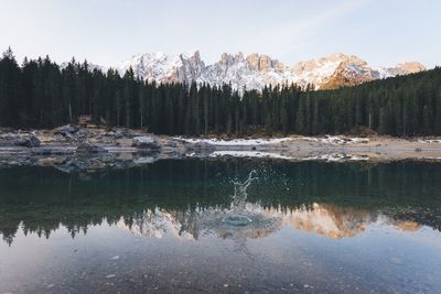 Reflection of trees and mountains in water with splash