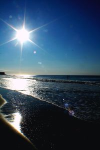 Sun shining through clouds over sea