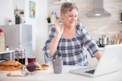 Midsection of woman using smart phone at home