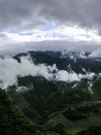 Scenic view of mountains against cloudy sky