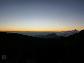 Scenic view of silhouette mountains against clear sky during sunset